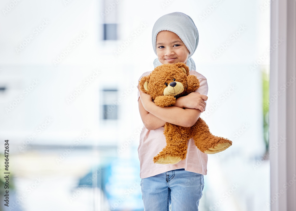 © Alexis Scholtz/peopleimages.com - Healthcare, child and portrait of a cancer patient holding a teddy bear for support or comfort. Medical, smile and girl kid with leukemia standing with a toy after treatment in a medicare hospital.