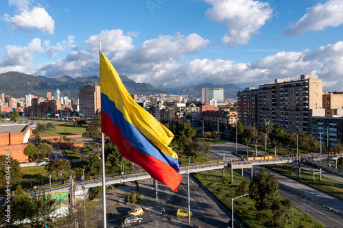 Fotomurale Photo of the Colombian flag on a pole with avenue and city buildings in the background