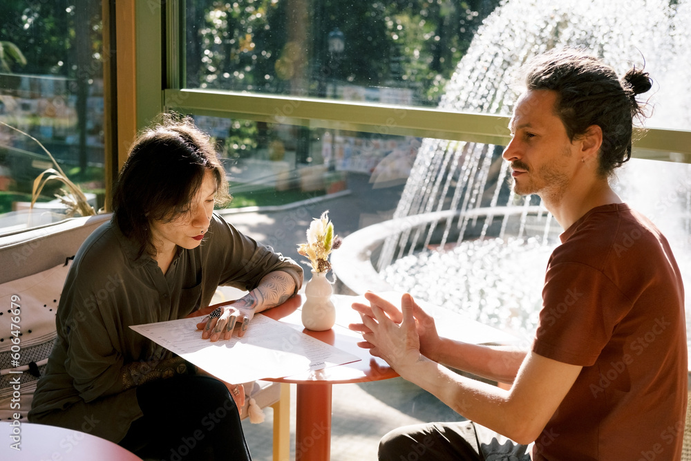 Ταπετσαρία A young couple of a man and a woman at a table in a cafe
