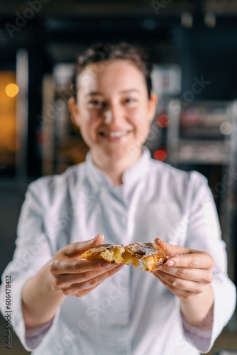 smiling pretty woman baker tearing ready freshly baked hot fragrant buns and checking dough showing bun bakery production © Guys Who Shoot