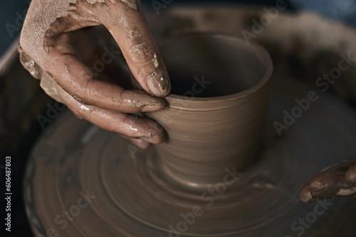 Hands of craftsman artist working on pottery wheel.