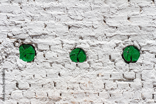 Minimalist anstract compostion with a white facade and three green circles formed by the extremities of wooden beams, Mongui (Monguí), Boyaca, Colombia. photo