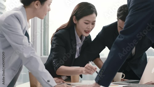 team of asian corporate executives meeting in office discussing business strategy led by a young woman