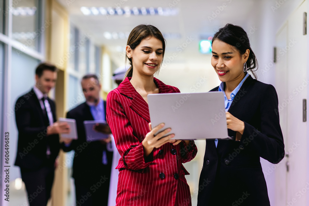Diverse friend partners colleagues talking walking in modern office hallway. Confident business partners walking down in office building and talking. Professional business people walking and talking Diverse friend partners colleagues talking walking in modern office hallway. Confident business partners walking down in office building and talking. Professional business people walking and talking