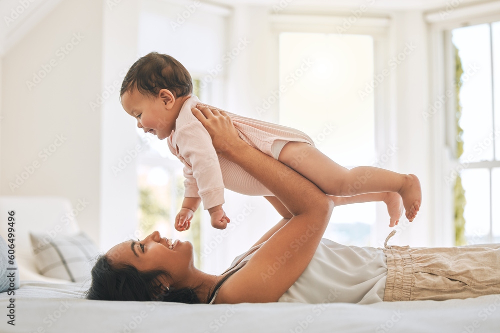 Fototapeta premium Mother, lifting baby and bedroom in family home for bonding, security or quality time. Happy woman or mom and girl child relax together on bed for development, trust and support or care for happiness