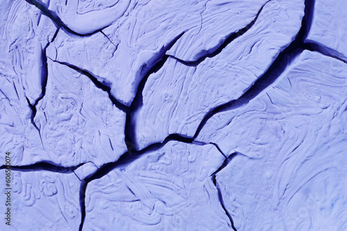 The cracks texture dried lilac paint.