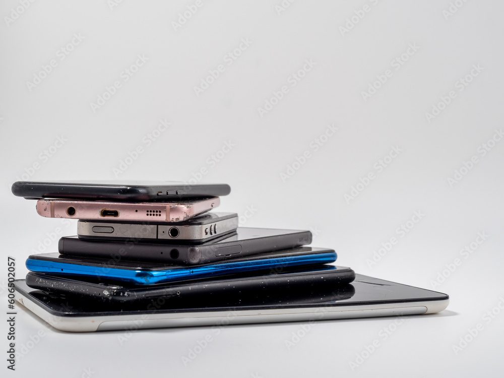 Damaged mobile phones. A bunch of broken smartphones. Used phones on a light background. Damaged mobile phones. A bunch of broken smartphones. Used phones on a light background.
