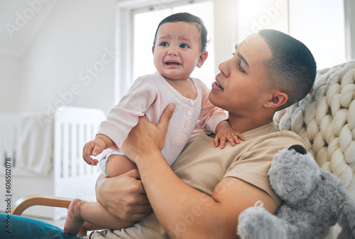 Father, holding baby and crying in a family home while hungry, tired or sad. Frustrated and confused man or dad and girl child cry on a sofa while sick, colic or sleepy on a living room couch