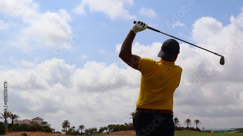 Professional golfer with one arm hitting the ball on the golf course. Concept of willpower of people with disabilities in sport.