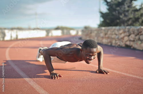 young man does a push-up on a running track