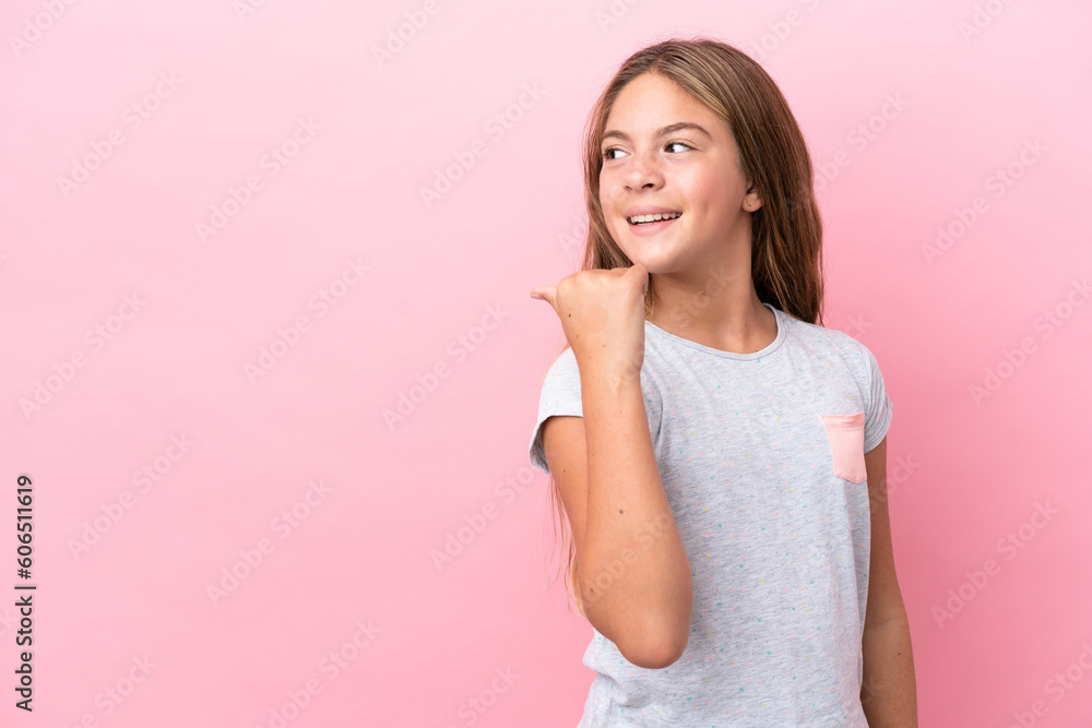 Little caucasian girl isolated on pink background pointing to the side to present a product Little caucasian girl isolated on pink background pointing to the side to present a product