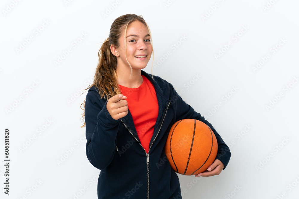 Little caucasian girl isolated on white background playing basketball and pointing to the front