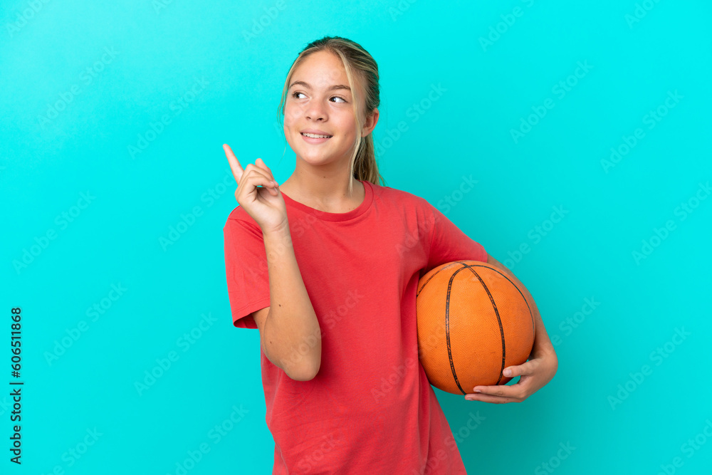 Little caucasian girl playing basketball isolated on blue background pointing up a great idea Little caucasian girl playing basketball isolated on blue background pointing up a great idea