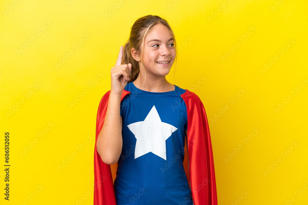 Super Hero little girl isolated on yellow background intending to realizes the solution while lifting a finger up Super Hero little girl isolated on yellow background intending to realizes the solution while lifting a finger up