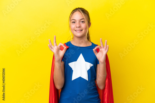 Принти на полотні Super Hero little girl isolated on yellow background showing an ok sign with fin