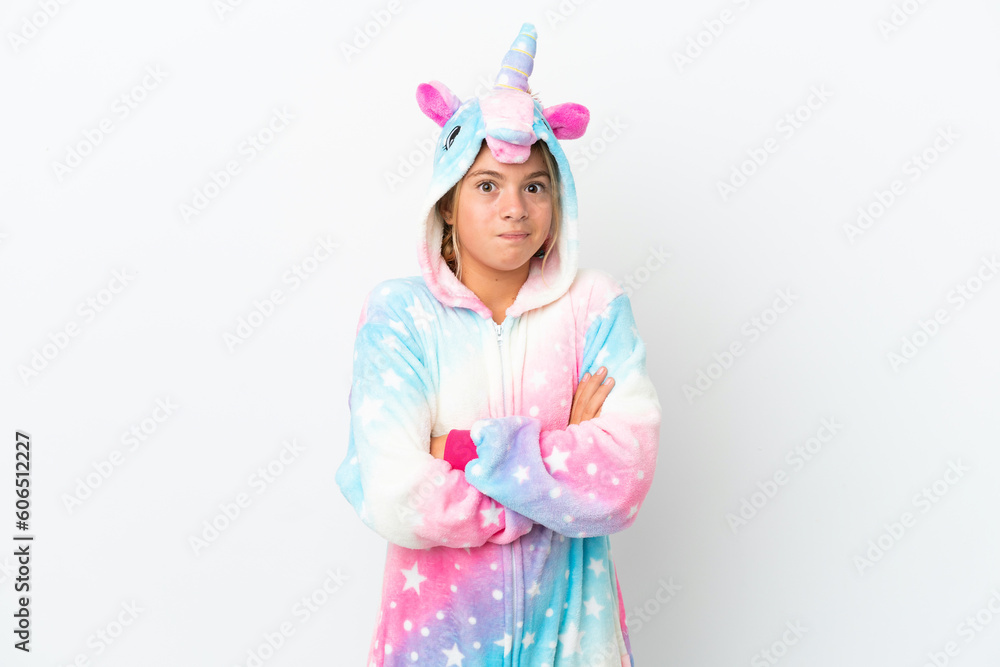 Little girl with unicorn pajamas isolated on white background making doubts gesture while lifting the shoulders