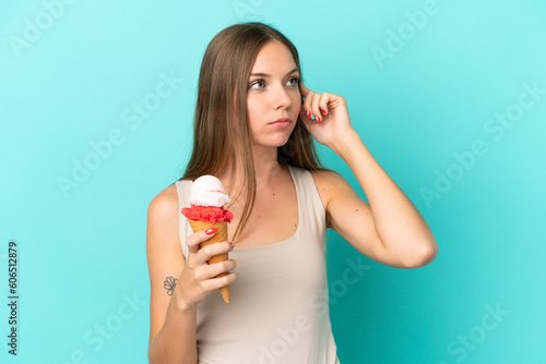 Young Lithuanian woman with cornet ice cream isolated on blue background having doubts and thinking
