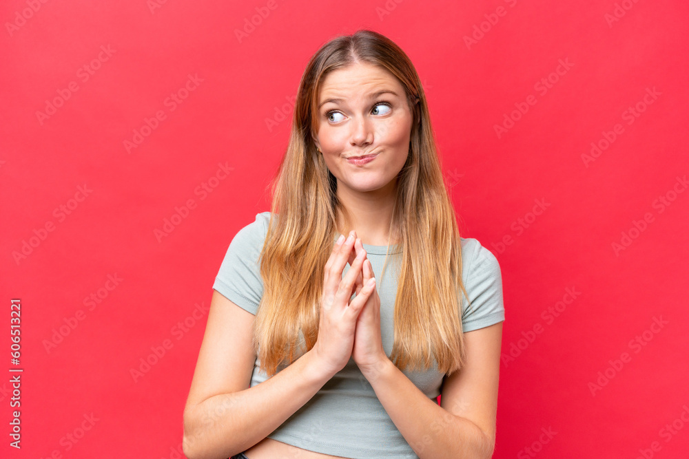 Young beautiful woman isolated on red background scheming something Young beautiful woman isolated on red background scheming something