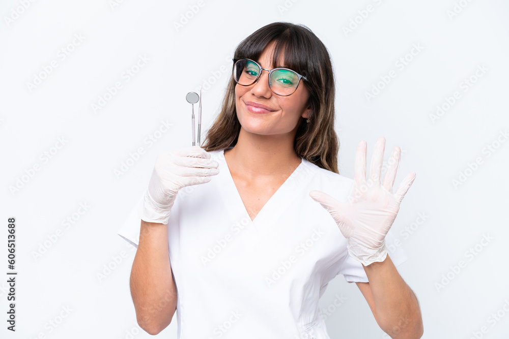 Dentist caucasian woman holding tools isolated on white background counting five with fingers Dentist caucasian woman holding tools isolated on white background counting five with fingers