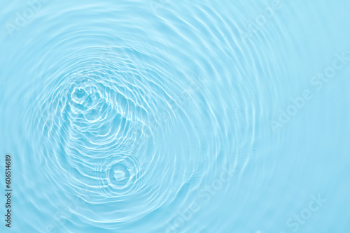 Water blue surface abstract background. Waves and ripples of cosmetic moisturizer with bubbles