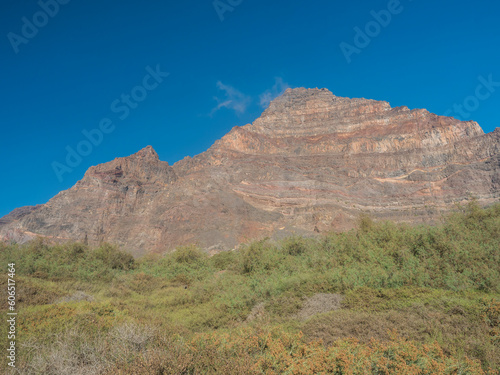 Scenic view on pink massive sharp cliffs and mountain Tequergenche in the La Mercia mountain range in Valle Gran Rey, La Gomera, Canary Islands, Spain, Europe. Blue sky background copy space.