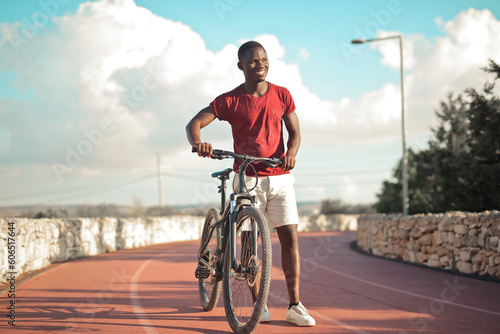 young man with a bicycle on a running track