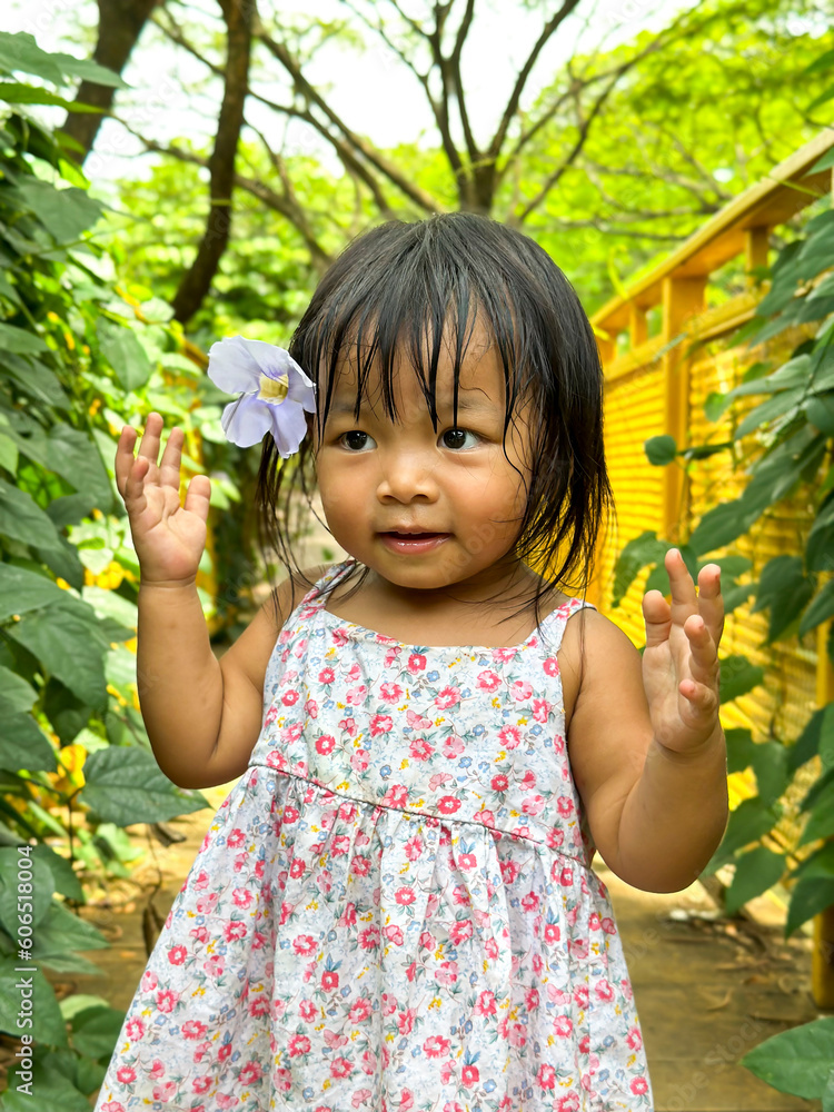 Portrait of a cute little baby girl with flower over ear. Selective focus Portrait of a cute little baby girl with flower over ear. Selective focus