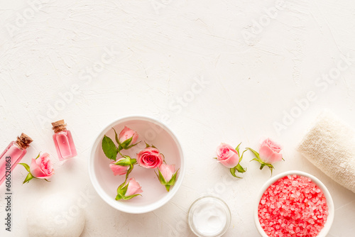 Pink roses cosmetic products set with flowers essential oil. Beauty care concept.