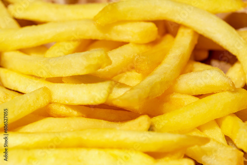 Fresh tasty fried french fries in sunlight close up. Selective focus, defocus