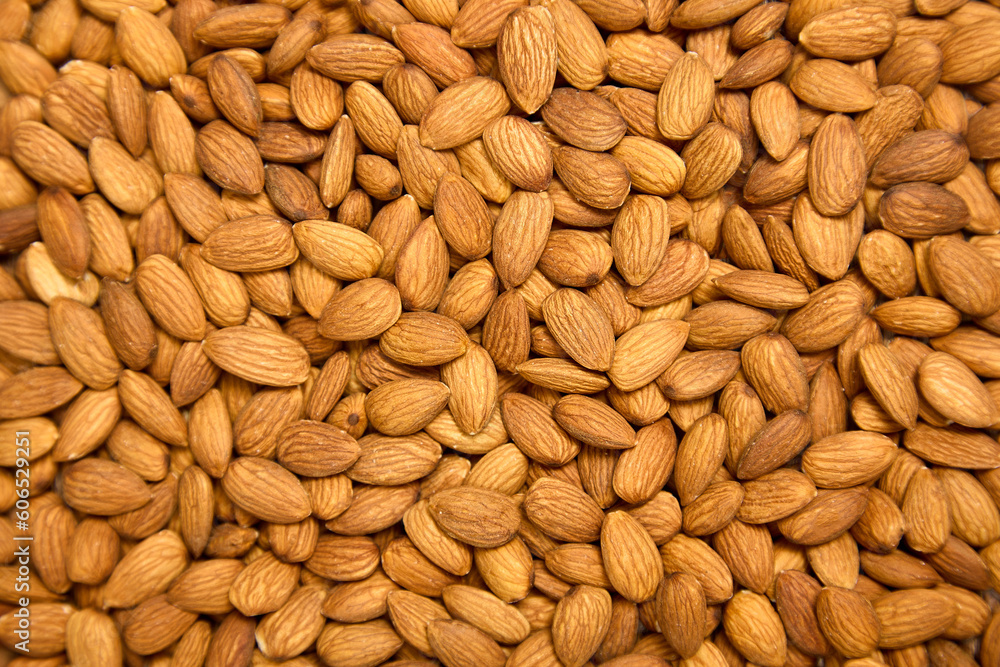 Background of brown large raw peeled almonds, arranged arbitrarily. A lot of delicious healthy almonds laid out in front of the camera, top view Background of brown large raw peeled almonds, arranged arbitrarily. A lot of delicious healthy almonds laid out in front of the camera, top view