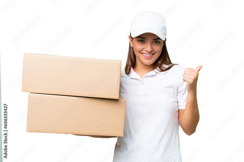 Delivery caucasian woman holding boxes isolated on green chroma background pointing to the side to present a product Delivery caucasian woman holding boxes isolated on green chroma background pointing to the side to present a product