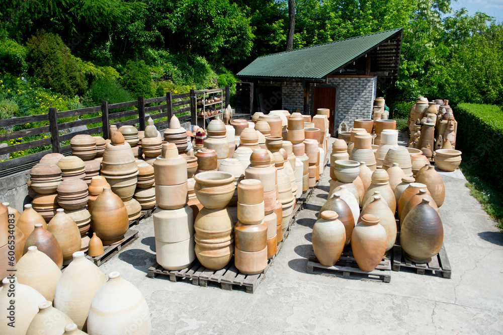Pottery jugs, amphorae and other items of various shapes standing in an open space. Pottery jugs, amphorae and other items of various shapes standing in an open space.