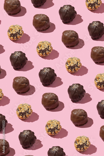 Chocolate craft nuts candies pattern on pink background. Sweet food background
