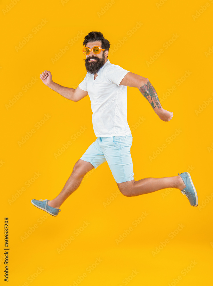 Obraz premium running caucasian stylish guy in studio isolated on yellow background