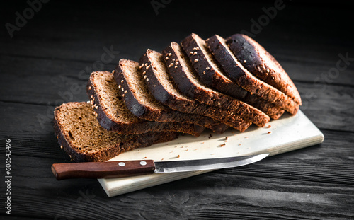black bread on a wooden board on a black background
