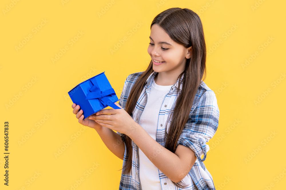 smiling teen girl with birthday gift isolated on yellow. teen girl with birthday gift in studio. smiling teen girl with birthday gift isolated on yellow. teen girl with birthday gift in studio.