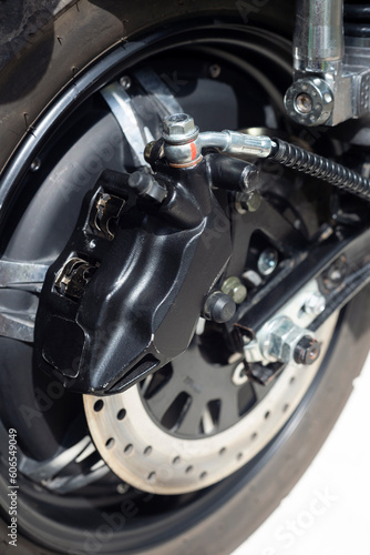 brake disc and caliper  rear wheel of an electric motorcycle  close-up selective focus