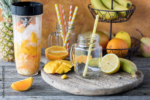 A blender container filled with ingredients for a fresh mango citrus smoothie.