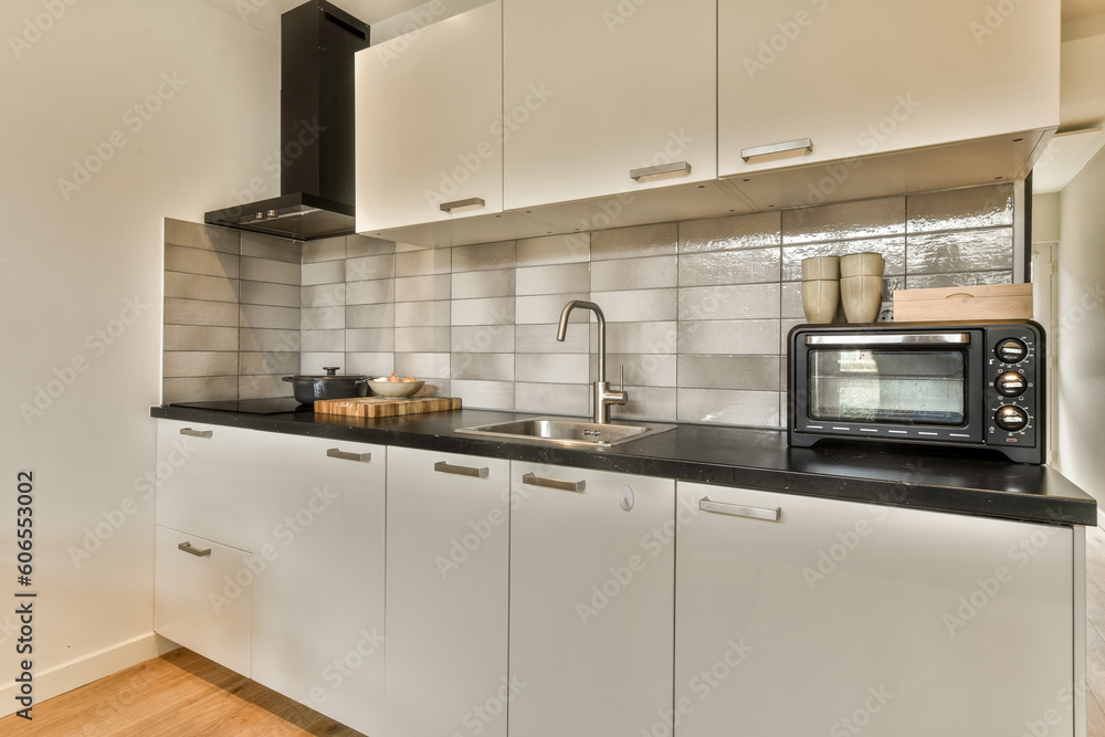 a kitchen with white cupboards and black counter tops on the counters in this photo is taken from the inside a kitchen with white cupboards and black counter tops on the counters in this photo is taken from the inside
