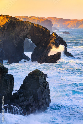 First light catching the Stac a Phris, a natural sea arch, on a windy day on the Isle of Lewis, Outer Hebrides, Scotland.