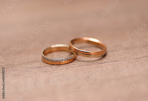 two golden wedding rings with diamonds on a blurred background