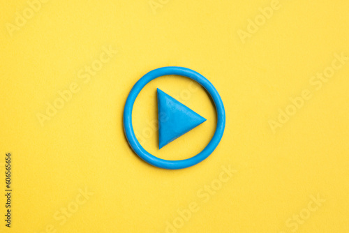  3d simple play button, 3d media play sign on yellow background. Plasticine object.
