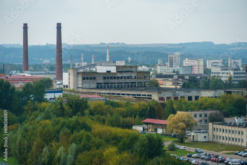 An oil refinery on the territory of the city. The plant is between the forest and the city. A chimney from a gas turbine plant emits poisonous smoke over the city.