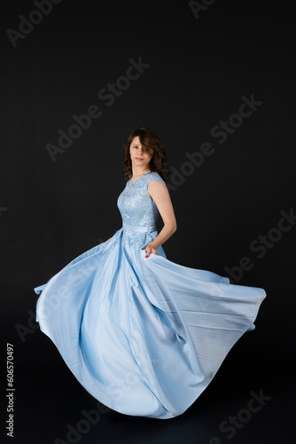 Beautiful young Bridesmaid in blue dress, posing. isolated on black background.