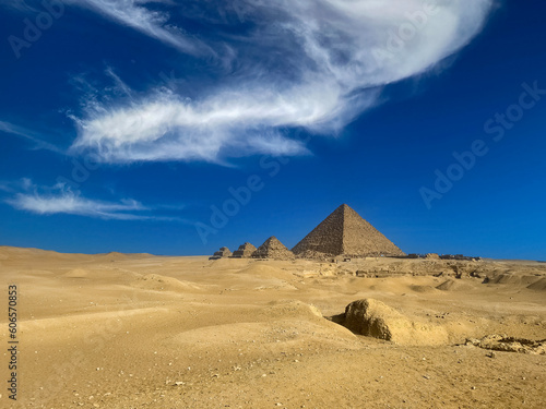 The  Pyramid of Menkaure  on the background of a bright blue sky with clouds. This is pyramid the smallest of the three main pyramids of the  Giza pyramid complex  located on the  Giza Plateau