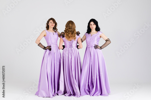 Group of three bridesmaids in purple dresses. isolated on white background.