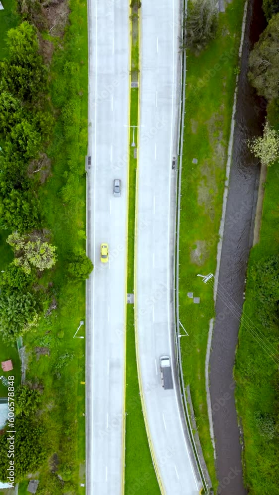 Vista aérea de tráfico de vehículos en dos carreteras y puente elevado sobre un río con naturaleza. Vista aérea de tráfico de vehículos en dos carreteras y puente elevado sobre un río con naturaleza.