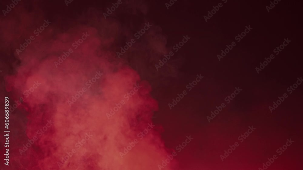 Vertical column of smoke on a black background. Multicolored flashing neon lights color the smoke clouds in vibrant colors. Texture and abstract art. Vertical column of smoke on a black background. Multicolored flashing neon lights color the smoke clouds in vibrant colors. Texture and abstract art.