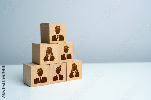 Pyramid of blocks with workers. Putting people in their places. Assemble a team of employees. How many workers can you effectively manage. Hiring and recruiting new members.