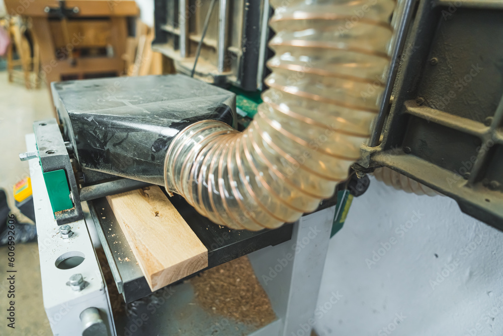 Obraz na plátně Wooden plank moving under sawdust extractor to make the environment free of dust